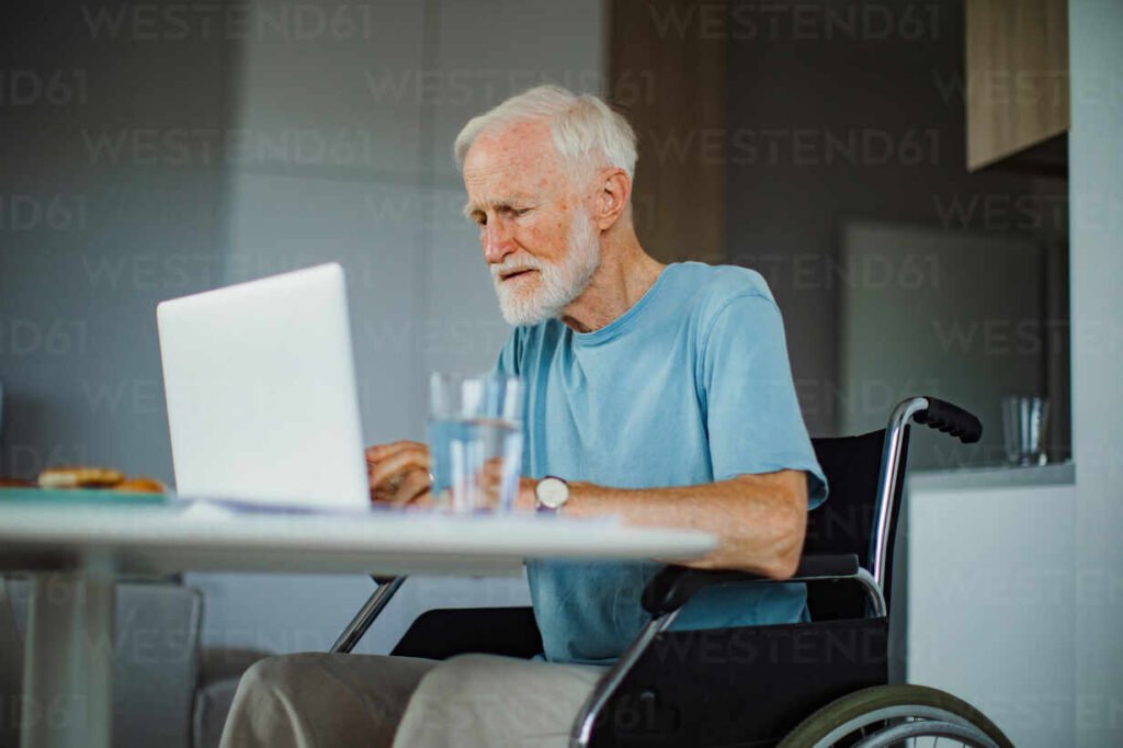 Senior man in a wheelchair working from home during retirement